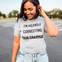 Woman wearing a Graphic t-shirt that says 'I’m Silently Correcting Your Grammar' – funny editor and teacher shirt
