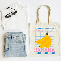 White t-shirt, blue jeans, black sunglasses, and a tote bag with banana design on a white background