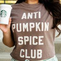 Person wearing a 'ANTI PUMPKIN SPICE CLUB' shirt holding a Starbucks cup.