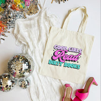 Tote bag with 'Good Girls Read Dirty Books' text, disco balls, and high heels on a white surface
