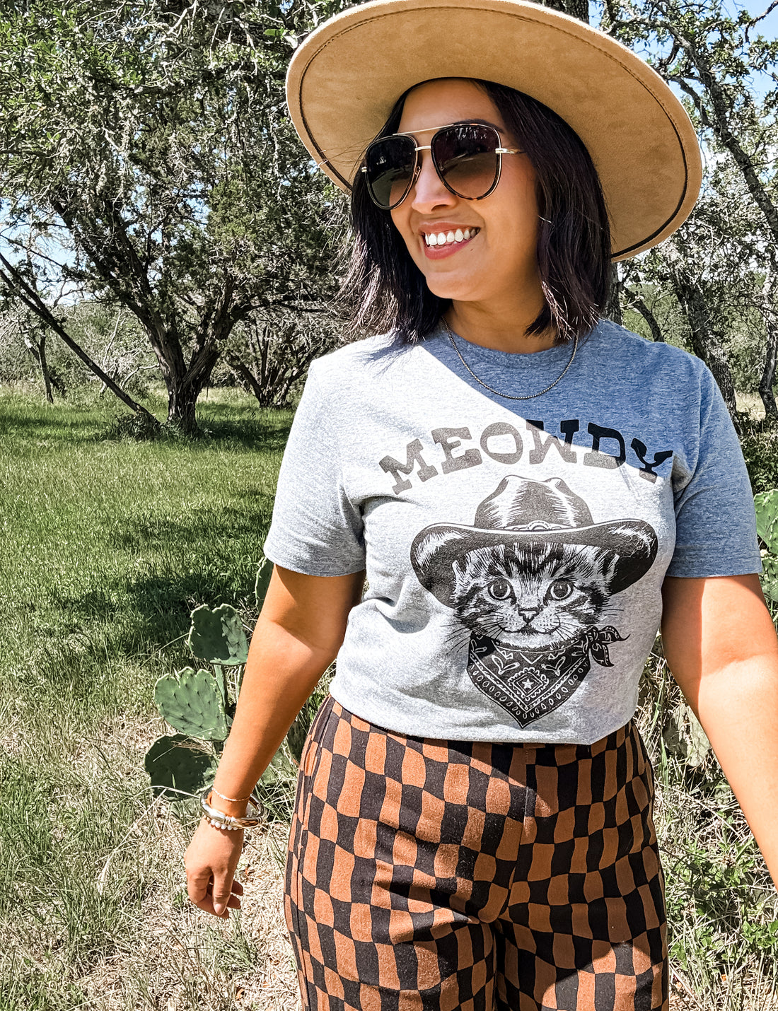 Person wearing a t-shirt with a cat graphic and &