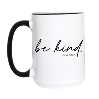 A white ceramic coffee mug with a black handle and black interior rim, featuring the printed black text 'be kind. .
