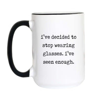 Funny glasses coffee mug with black typewriter text reading "i've decided to stop wearing glasses. i've seen enough." on a white mug with black accent handle and rim