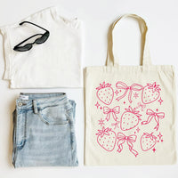 White t-shirt, blue jeans, black sunglasses, and a tote bag with strawberry and bow pattern on a white background