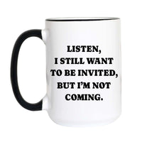 A white ceramic coffee mug with a black handle and black rim, featuring the printed text 'LISTEN, I STILL WANT TO BE INVITED, BUT I'M NOT COMING.' in bold black capital letters.