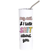 A white insulated tumbler with a clear lid and metal straw, printed with the phrase 'my cat & I talk SHIT about you' in black, pink, yellow, and light blue lettering, on a plain white background.
