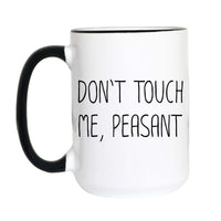 A white ceramic coffee mug with a black handle and black interior rim, featuring the text 'DON'T TOUCH ME, PEASANT' printed in black on the side.