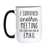 A white ceramic mug with a black handle and black rim, featuring the printed text 'I SURVIVED another MEETING that should have been an EMAIL' in black lettering on the front.