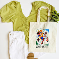 Green top, white pants, beige sandals, and a tote bag with a graphic design on a white background