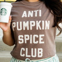 Person wearing a 'ANTI PUMPKIN SPICE CLUB' shirt holding a Starbucks cup.