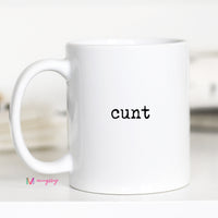 White mug with the word 'cunt' printed on it, brand 'Mugrug' visible.