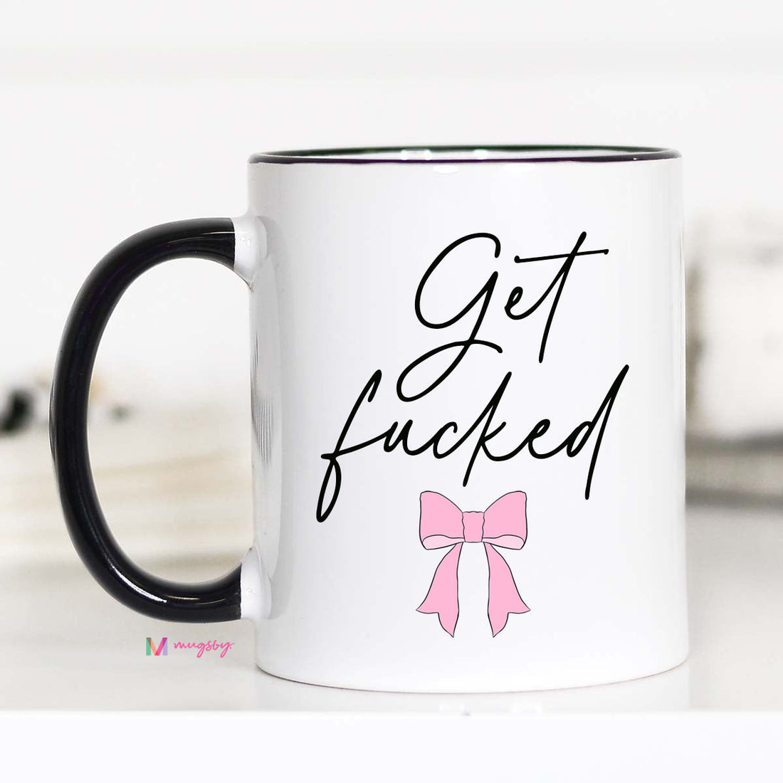 Mug with offensive text and a pink bow graphic on a white background