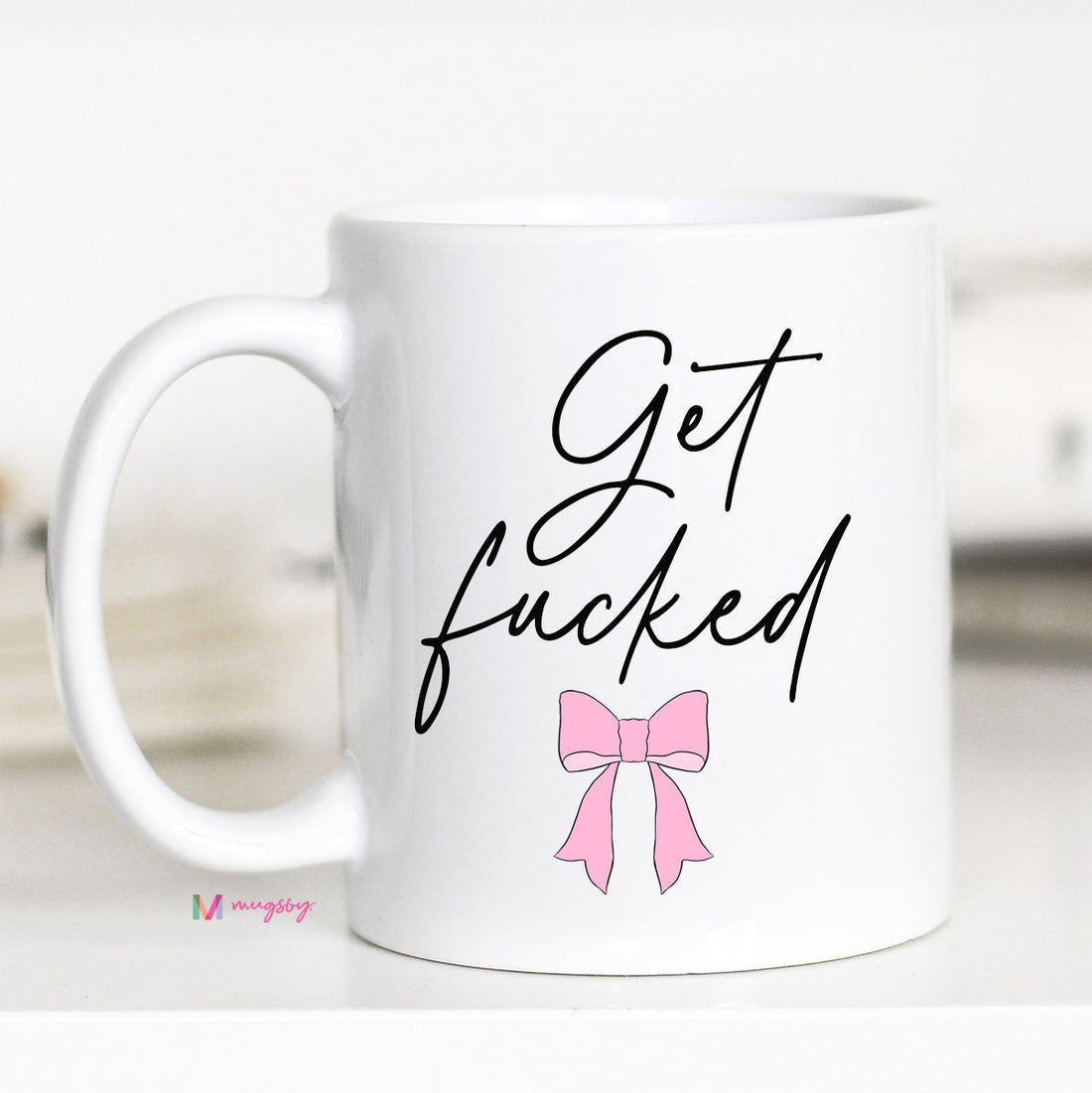 White mug with black text and a pink bow on a white background