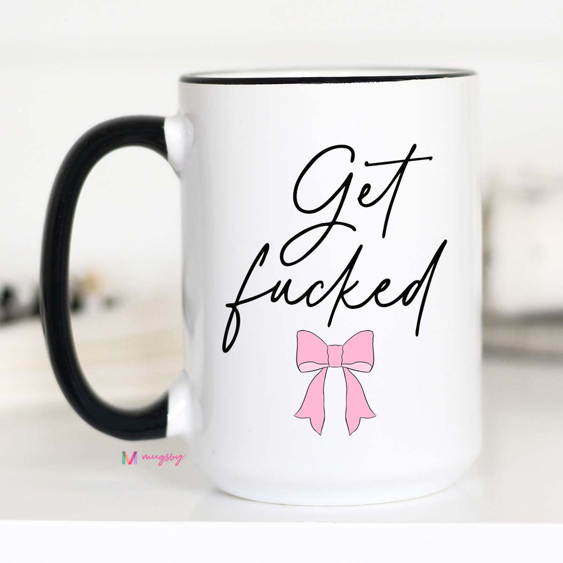White mug with black interior and handle, featuring a pink bow and text on a white background.