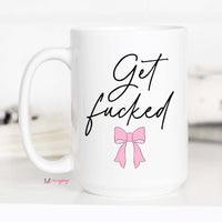 White mug with black text and a pink bow on a white background