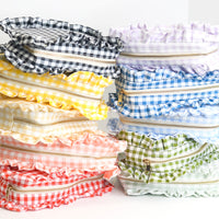 Stack of colorful checkered bags with zippers on a white background
