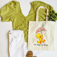 Green top, white pants, brown sandals, and a tote bag with a duck graphic on a white background