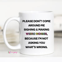 A white ceramic coffee mug with black text and a black handle, featuring the phrase 'Please Don't Come Around Me Sighing & Making Weird Noises, Because I'm Not Asking You What's Wrong.'.