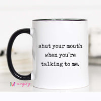 White mug with black interior and handle, featuring text 'shut your mouth when you're talking to me.' on a white background.