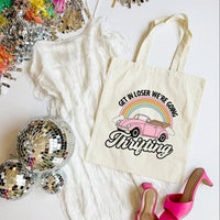 Tote bag with a car and rainbow design, surrounded by disco balls and high heels on a white surface.
