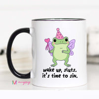 Mug with a cartoon frog character and text 'wake up, sluts. it's time to sin.' on a white background.