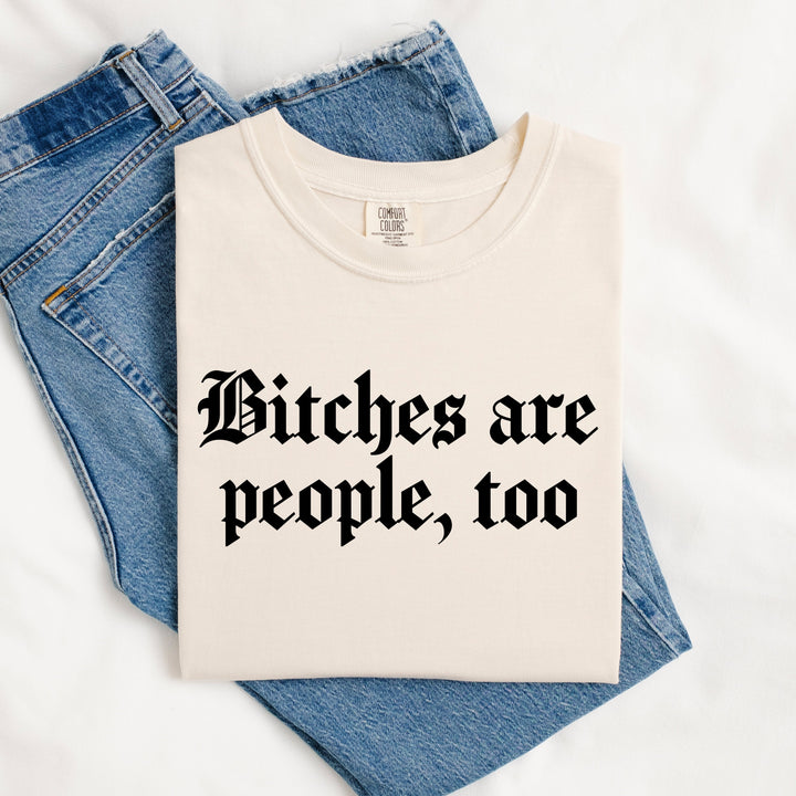White t-shirt with 'Bitches are people, too' text on blue jeans