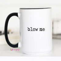 White mug with black handle and 'blow me' text on a white background