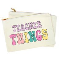 An off-white canvas zippered pouch with gold-tone zippers, featuring the words 'TEACHER THINGS' in a retro, multi-colored bubble font on the front.