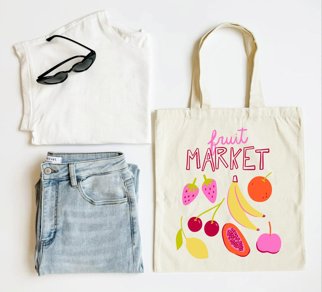 White t-shirt, blue jeans, sunglasses, and a tote bag with fruit design on a white background