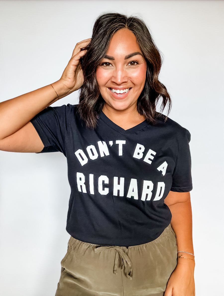 Woman wearing a black t-shirt with 'DON'T BE A RICHARD' text on a white background