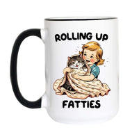 Funny fat cat coffee mug featuring a vintage child wrapping a chubby tabby cat in a blanket with the phrase "Rolling Up Fatties."