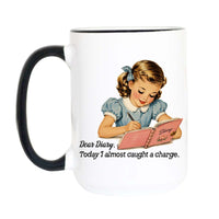 A white ceramic mug with a black handle and black rim, featuring a vintage-style illustration of a young girl writing in a pink diary and the text 'Dear Diary. Today I almost caught a charge.