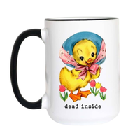 A white ceramic coffee mug with a black handle and black rim, featuring a cartoon illustration of a yellow duckling wearing a blue bonnet and pink bow, with the text 'dead inside' printed below.