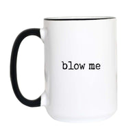 Funny rude coffee mug with black typewriter text reading "blow me" on a white mug with black accent handle and rim