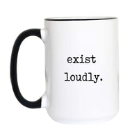 Inspirational coffee mug with black typewriter text reading "exist loudly." on a white mug with black accent handle and rim

