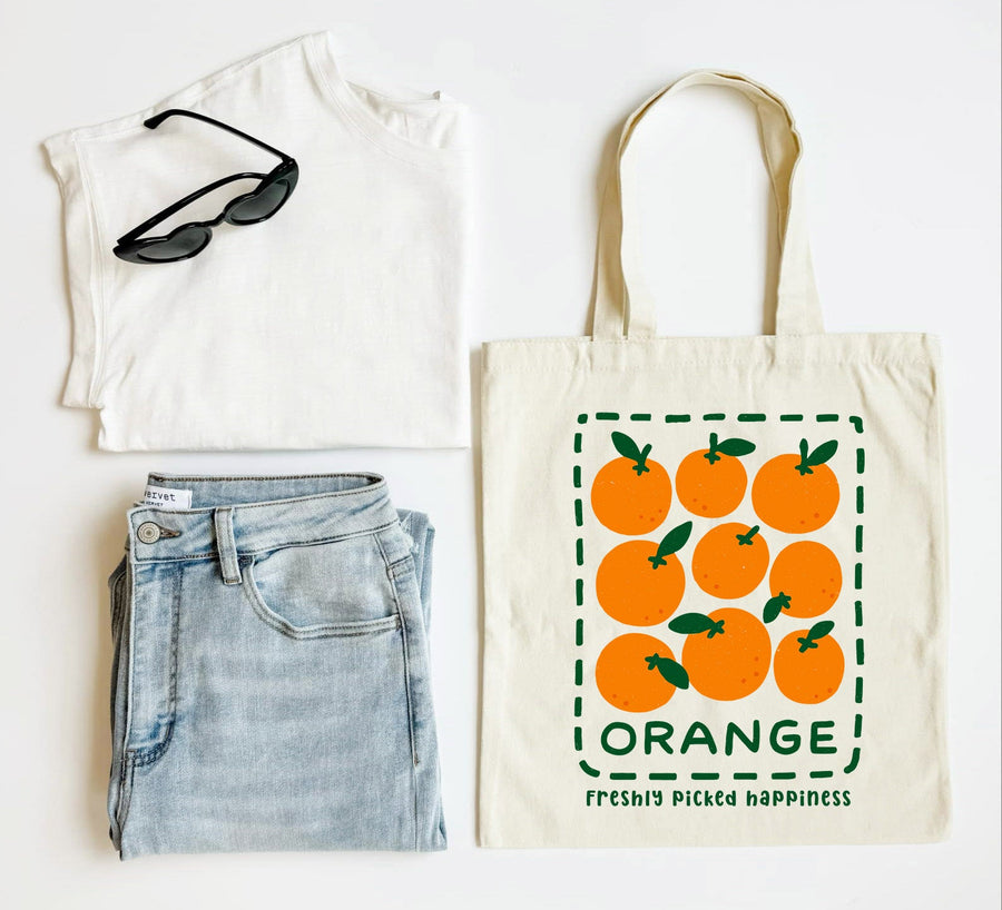 White t-shirt, blue jeans, sunglasses, and a tote bag with orange design on a white background