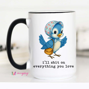 Mug with a cartoon blue bird wearing a floral hat and text 'i'll shit on everything you love'.