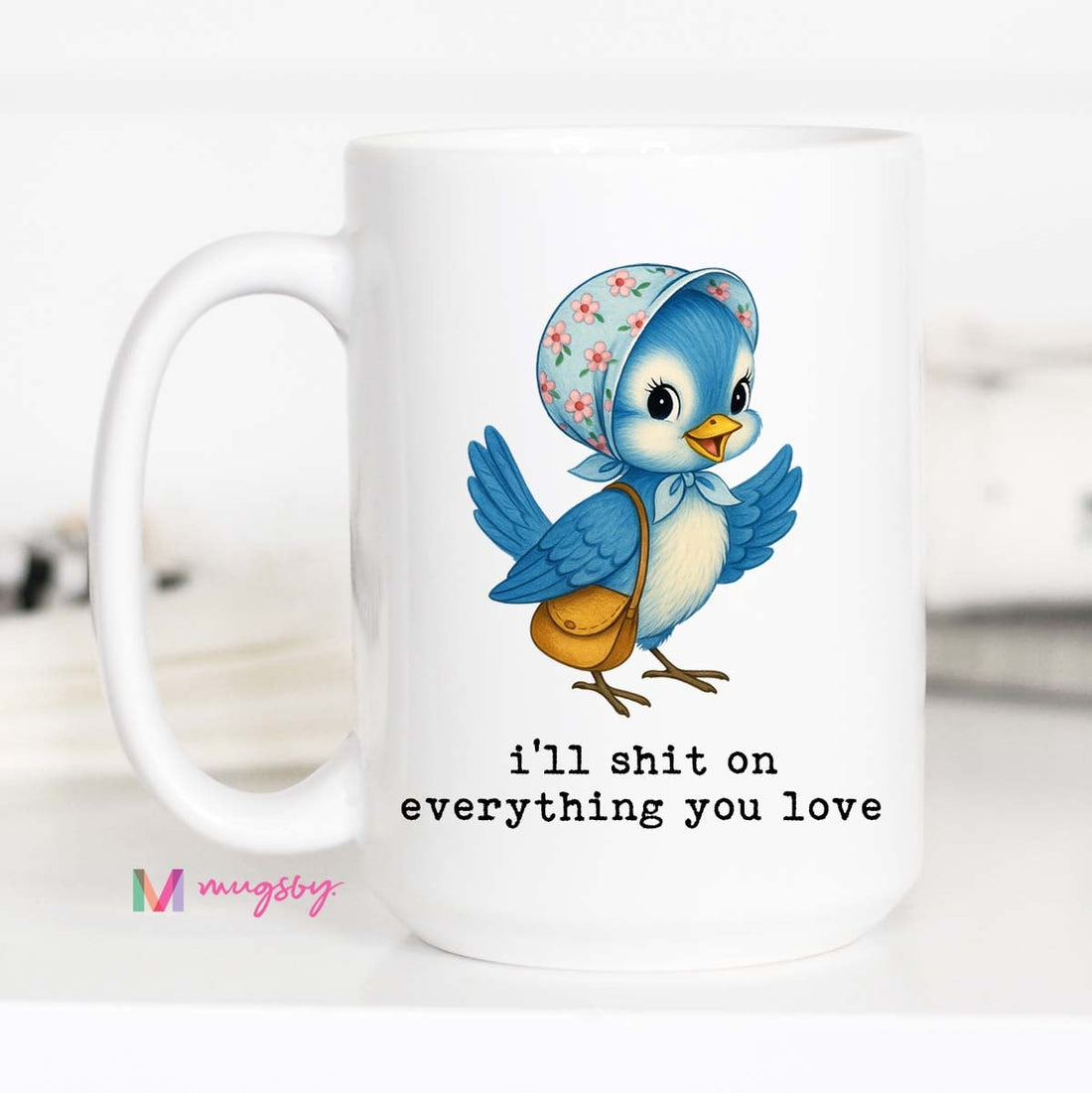 White mug with a cartoon blue bird wearing a floral headscarf and text &