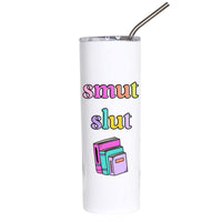A white insulated tumbler with a clear lid and metal straw, featuring the text 'smut slut' in pastel rainbow colors and a small stack of colorful books graphic on the front.