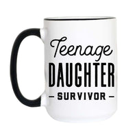 A white ceramic coffee mug with a black handle and black rim, featuring the text 'Teenage DAUGHTER SURVIVOR' printed in black on the front.