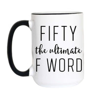 A white ceramic mug with a black handle and black rim, featuring the text 'FIFTY the ultimate F WORD' printed in black on the front, set against a plain white background.