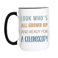 A white ceramic mug with a black handle and black interior rim, printed with the humorous phrase 'LOOK WHO'S ALL GROWN UP AND READY FOR A COLONOSCOPY' in blue and orange lettering.