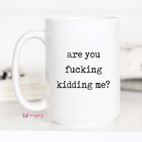 White mug with black text 'are you fucking kidding me?' on a white background