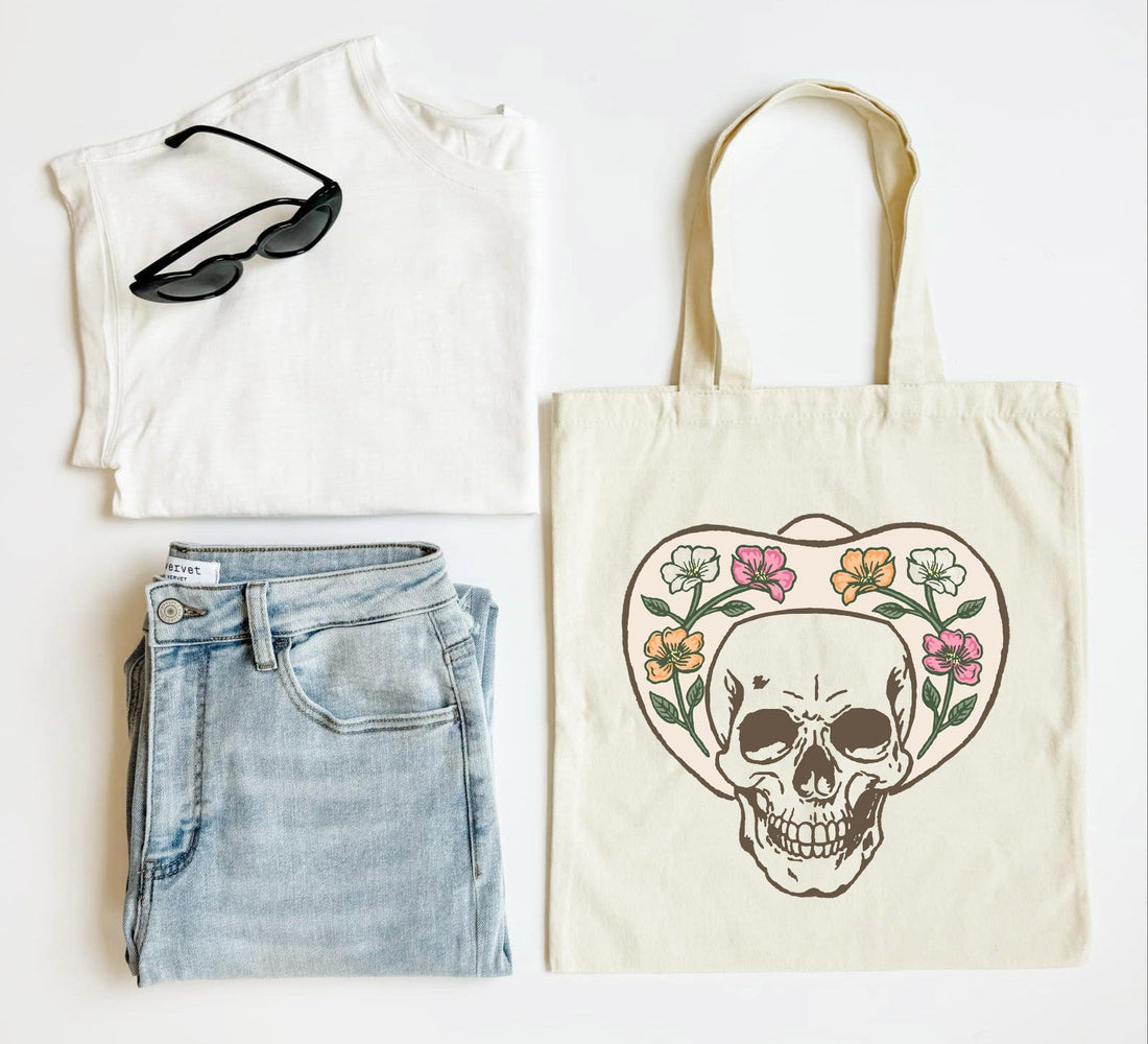 White tank top, blue jeans, black sunglasses, and a tote bag with a skull design on a white background