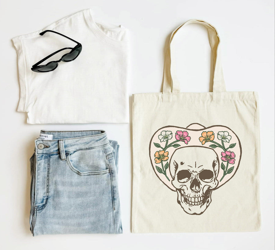 White tank top, blue jeans, black sunglasses, and a tote bag with a skull design on a white background