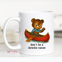 White mug with a bear in a canoe illustration and text 'don't be a douche canoe' on a white background.