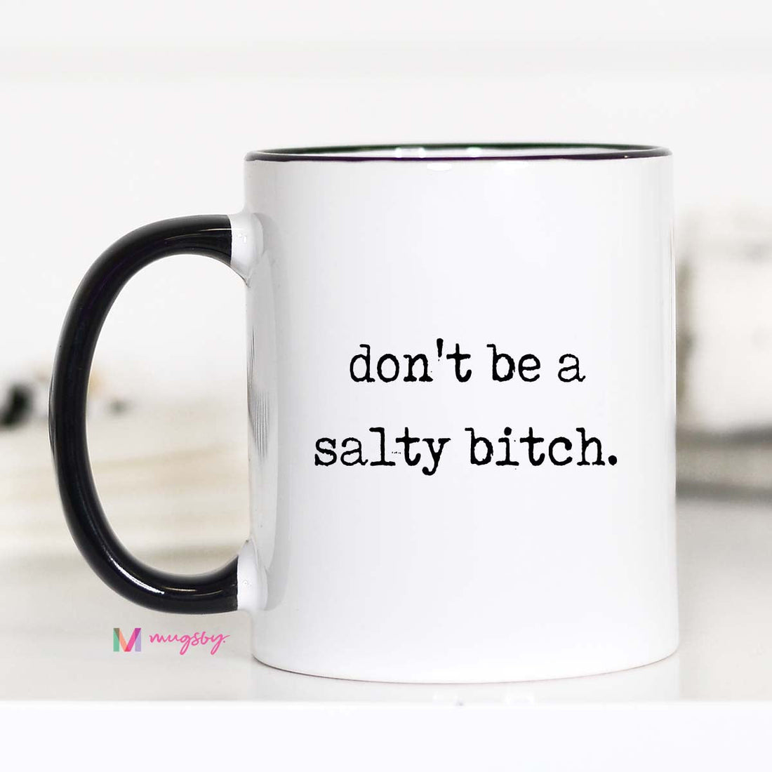 White mug with black interior and handle, featuring the text &
