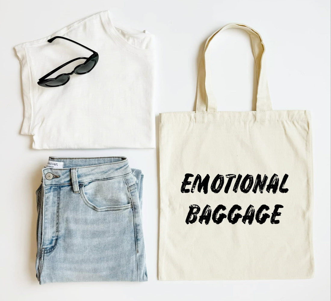 White tank top, blue jeans, black sunglasses, and a tote bag with &