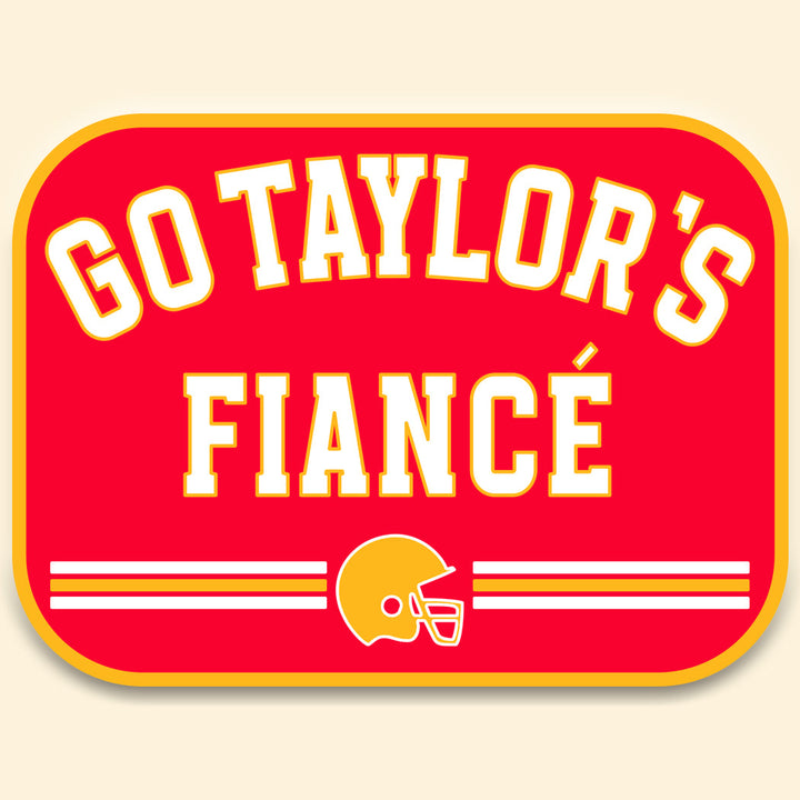 Red sign with 'GO TAYLOR'S FIANCE' text and football helmet graphic on a beige background