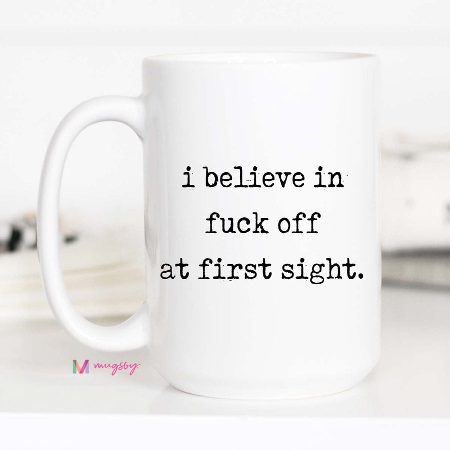 White mug with text 'i believe in fuck off at first sight' on a white background
